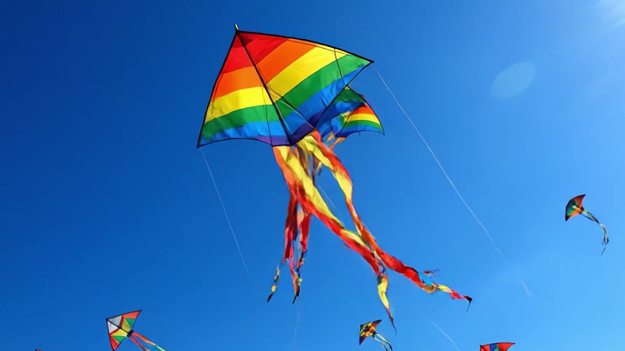 Uno spettacolo vibrante di aquiloni colorati che danzano nel cielo azzurro e limpido in una splendida giornata, catturando la gioia e la libertà delle attività di volo all'aperto.