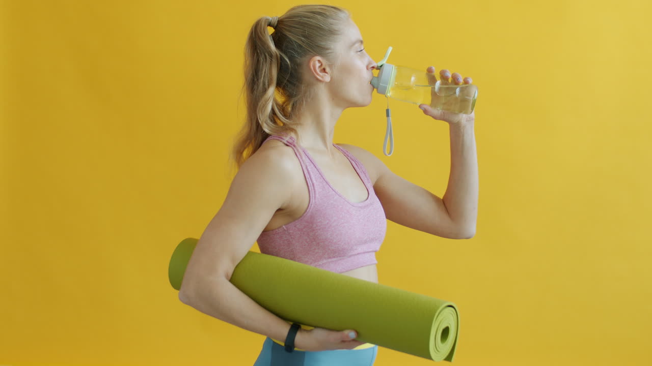 Woman drinking water after yoga practice