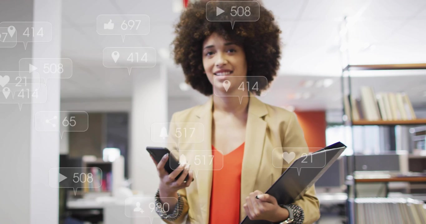 Woman checking smartphone for alerts in office, causing animated social icons rising and fading