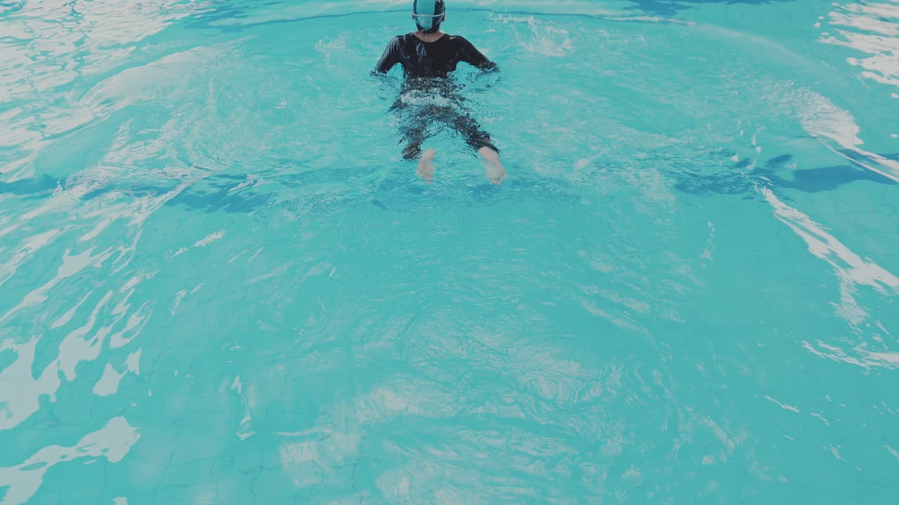 Giovane nuotatore che esegue lo stile a rana in piscina