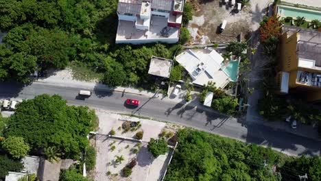 an aerial shot of a clean road where few cars are seen running on the asphalt road at isla mujeres mexico