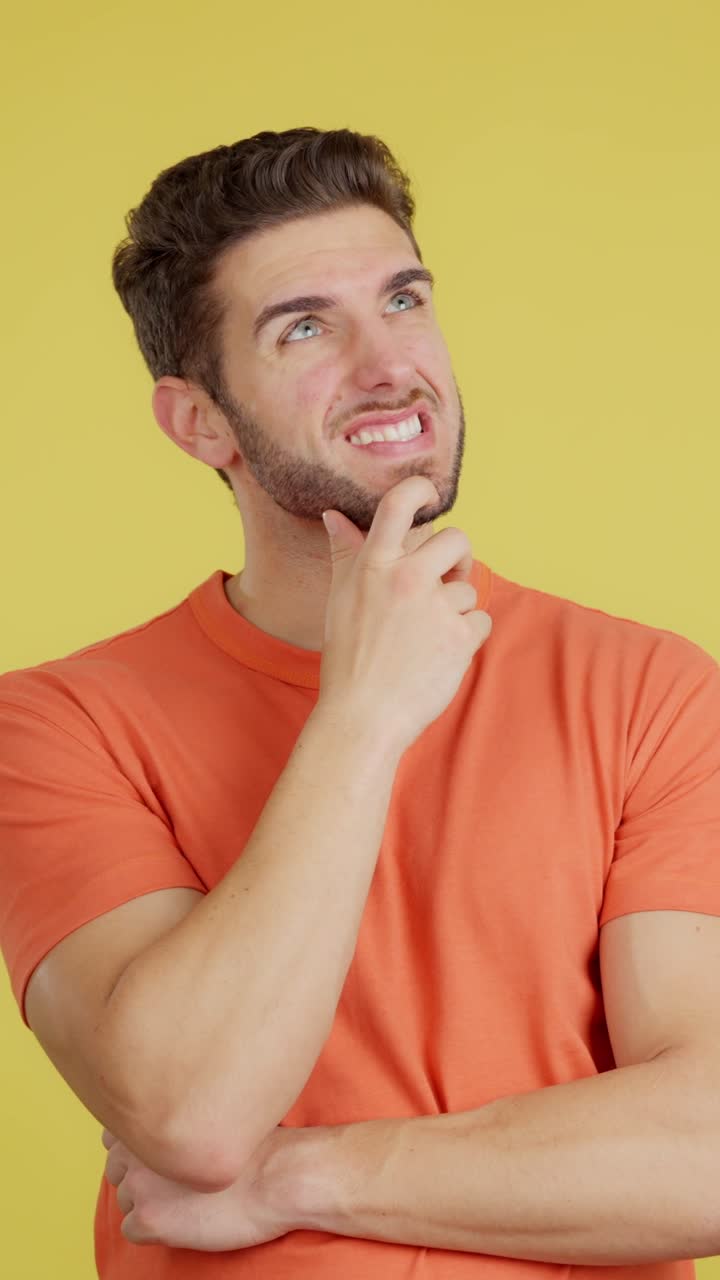Man with thoughtful expression on yellow background
