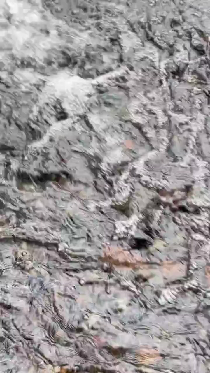 Acqua limpida che scorre su rocce di fiume