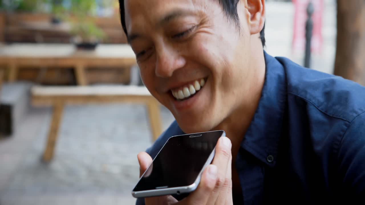 야외 카페 4k에서 휴대 전화로 이야기하는 남자