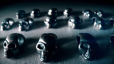 mini silver skulls on a table in the dark