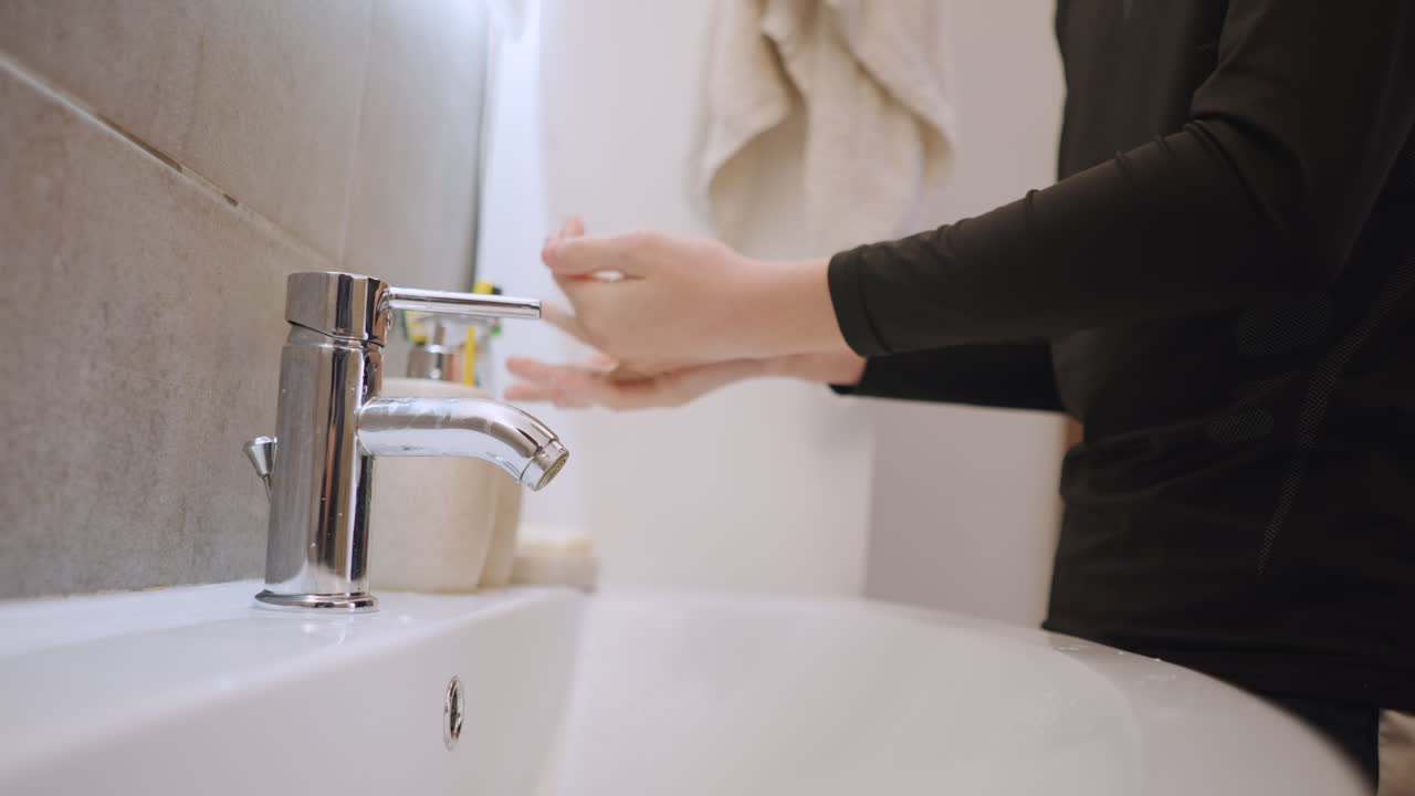 Bambino si pulisce le mani al lavandino. Nipotino si lava accuratamente le mani in un ambiente caldo e familiare del bagno. Giovane nipotino si pulisce delicatamente le mani in un accogliente bagno di casa con schiuma di sapone