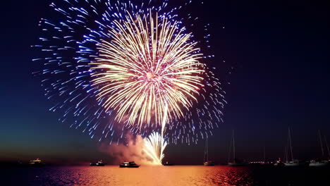 fuegos artificiales sobre el agua por la noche