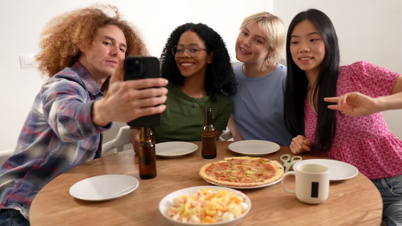 Amici che si fanno un selfie a un tavolo con pizza e birra