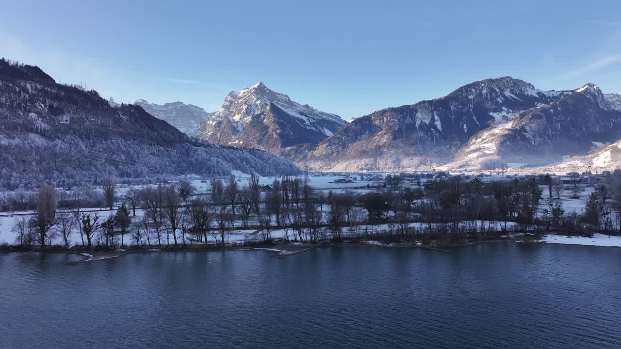 Breathtaking aerial view of the stunning Lake Walensee and the surrounding snow-covered mountains in Switzerland. A majestic winter landscape.