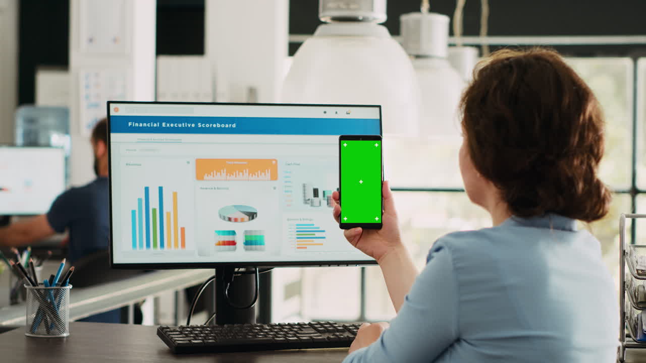 el empleado mira la pantalla verde en el teléfono