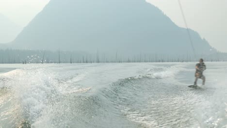 Vorderansicht-Eines-Kaukasischen-Jungen-Mannes,-Der-Tricks-Auf-Dem-Wakeboard-Im-Stadtfluss-Macht,-4k