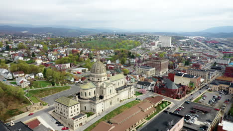 aerial drone flying over small, rural downtown of altoona pennsylvania in the summer showcasing the buildings and large church