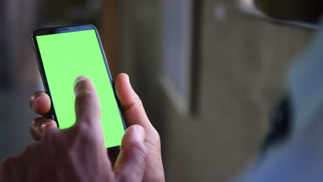 Man-using-smartphone-touchscreen,-close-up,-green-screen