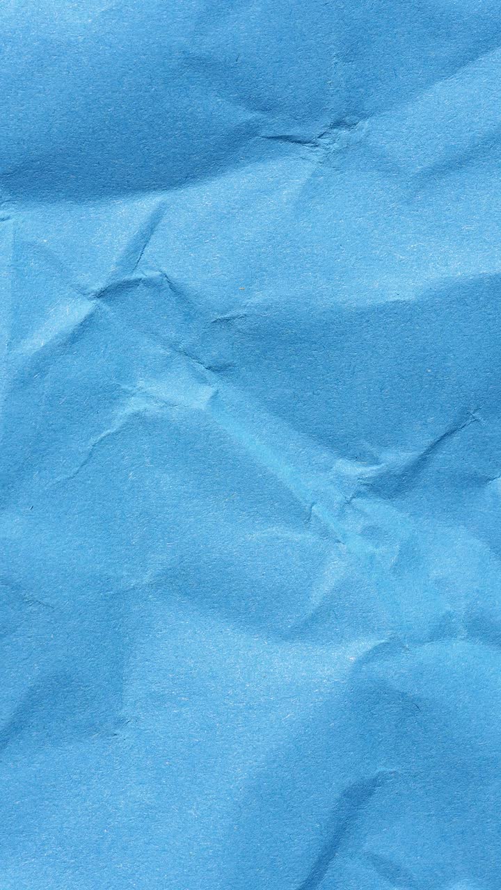 Vertical stop motion of wrinkled blue paper texture, seamless loop