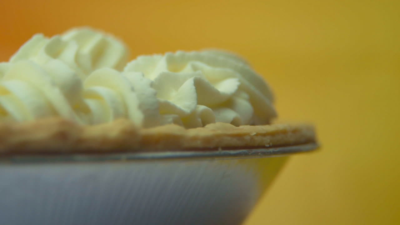 [использованная камера: canon c300] крупный план, низкий угол, вращающийся тыквенный пирог, загруженный пушистыми взбитыми сливками