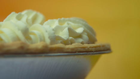 [camera used: canon c300] close-up, low angle, rotating pumpkin pie loaded with fluffy whipped cream