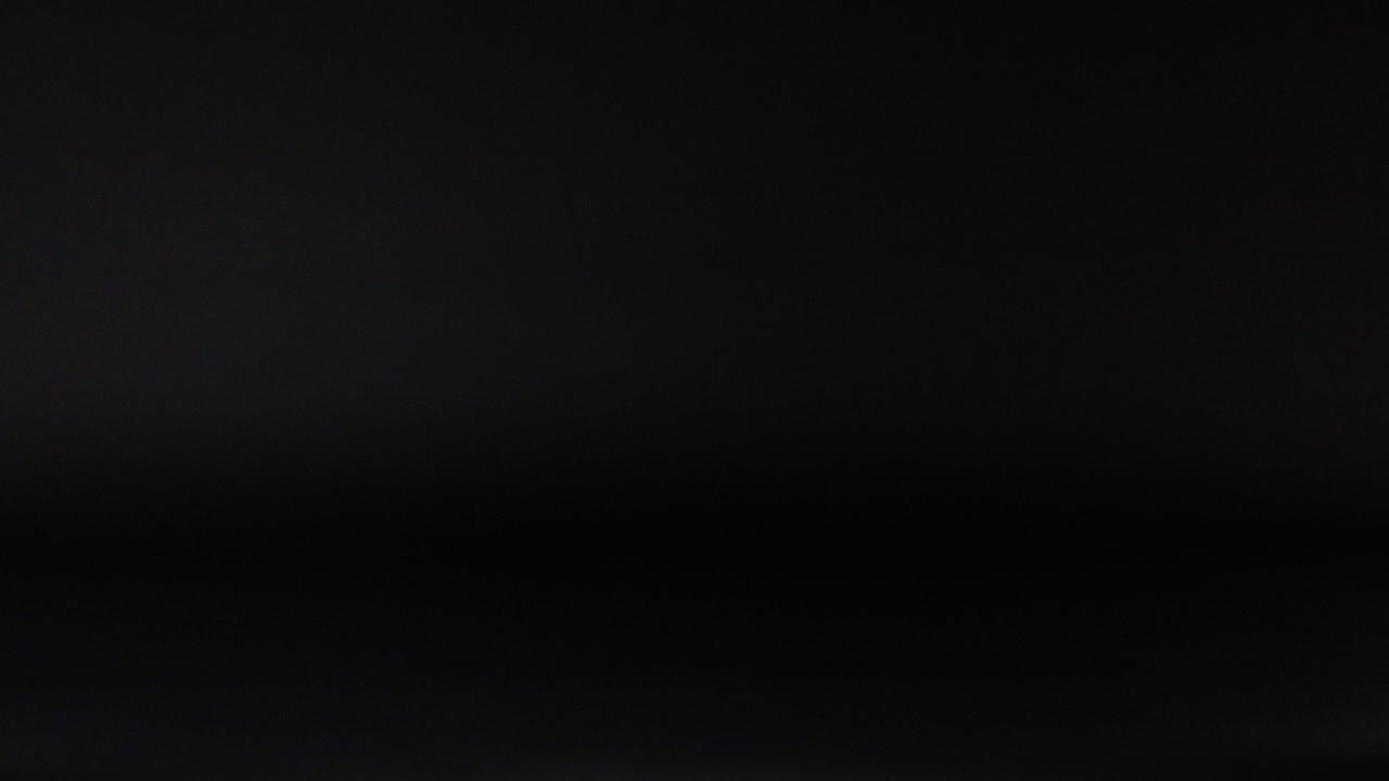 una pelota de tenis se mueve a través de un fondo oscuro