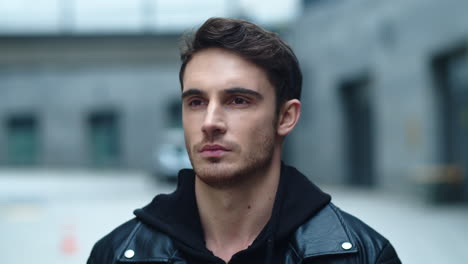 closeup young man looking camera on urban background. portrait of handsome man