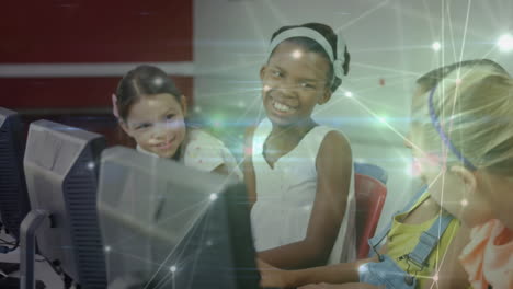 animation of glowing network of connections moving over happy schoolchildren using computers