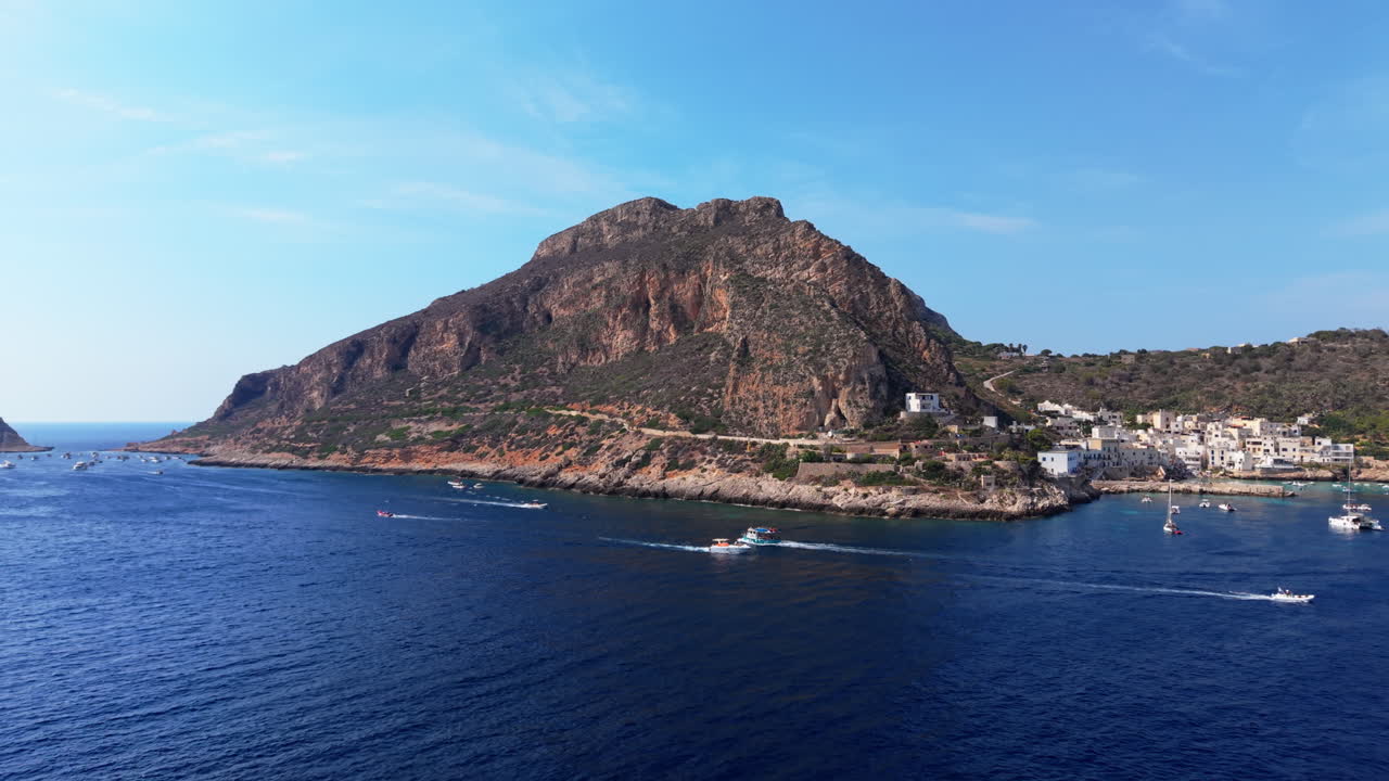 Boats sailing near a scenic mountainous coast in sunny Sicily, Italy