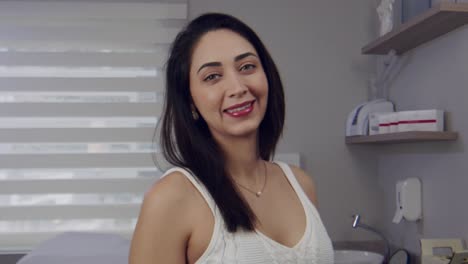 young hispanic woman in a doctor's office smiles