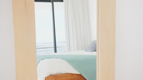 modern bedroom with cozy bed and light blue blanket, reflecting in mirror, at home