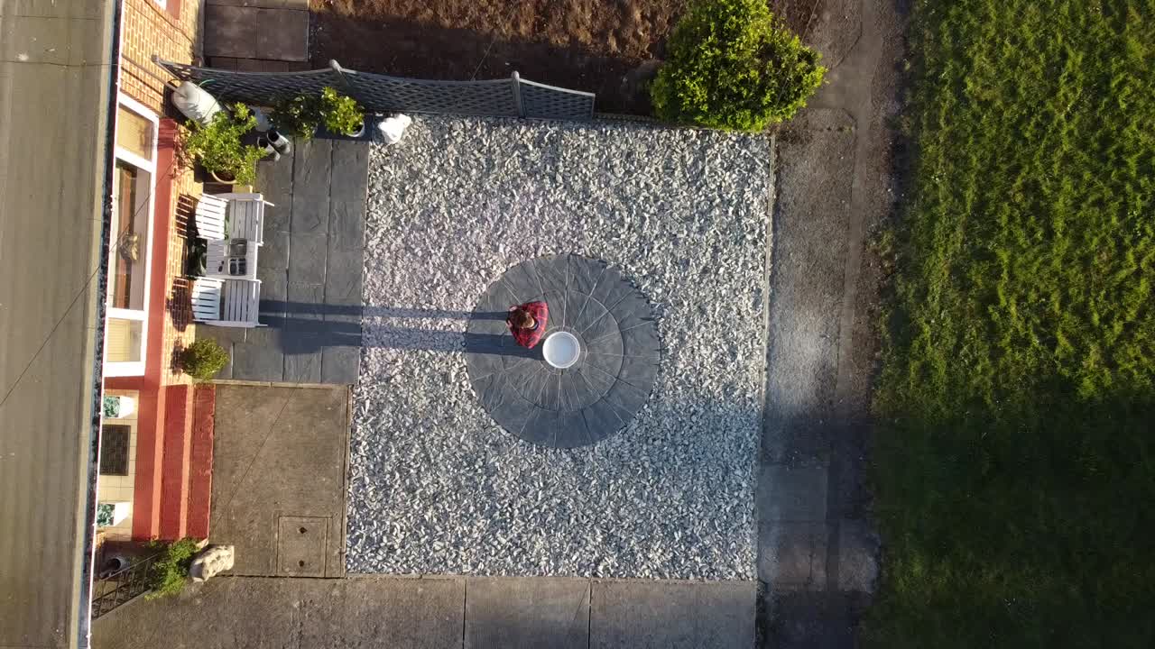 조감도의 아름다움을 보여주는 풀업 드론 샷으로 정원에 서있는 남자의 비디오