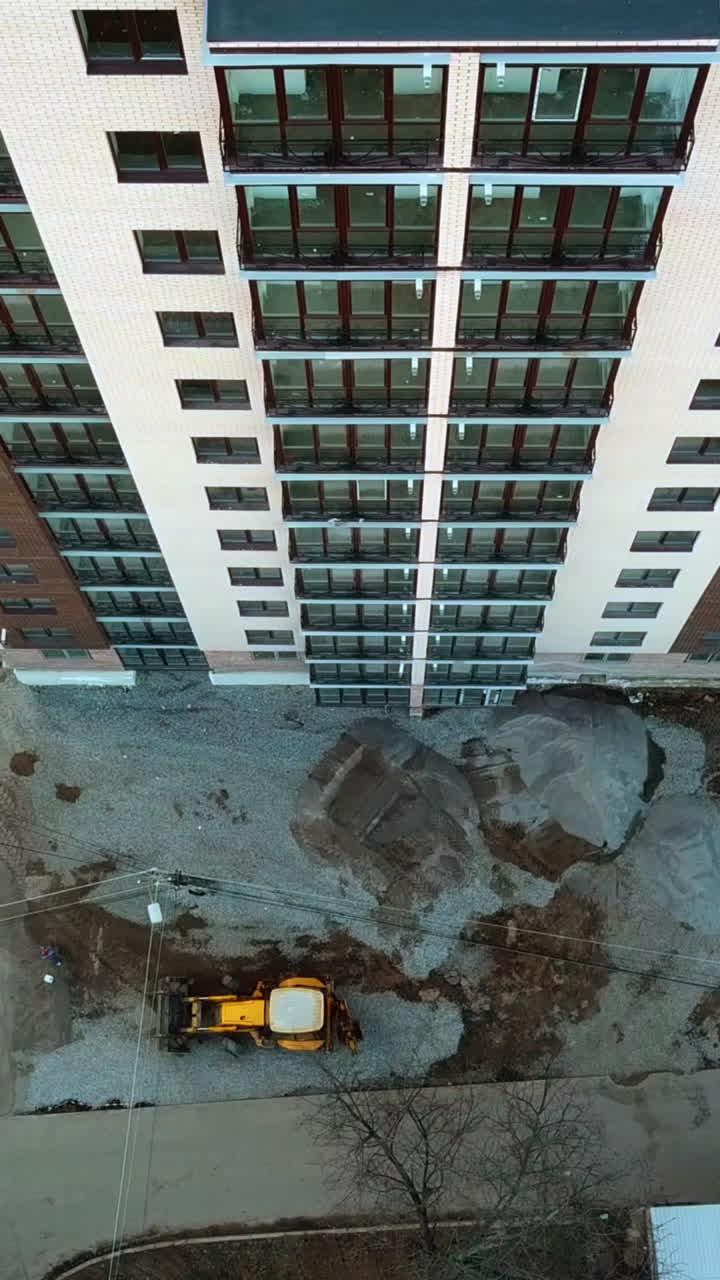 Construction of modern building. Aerial view of high construction building Vertical video