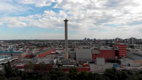 drone volando más allá del bosque revelando las fábricas de la ciudad de melbourne