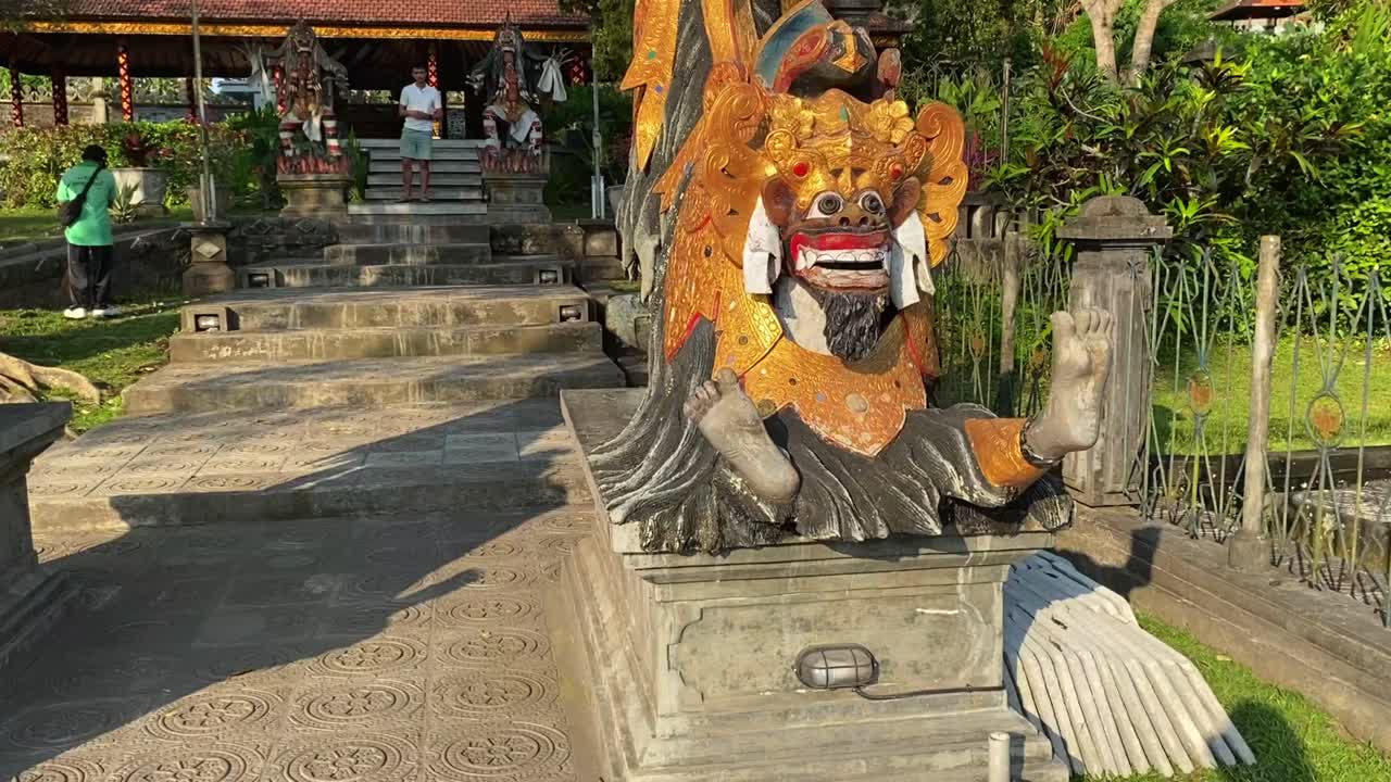 Balinese Temple Statue and Visitors