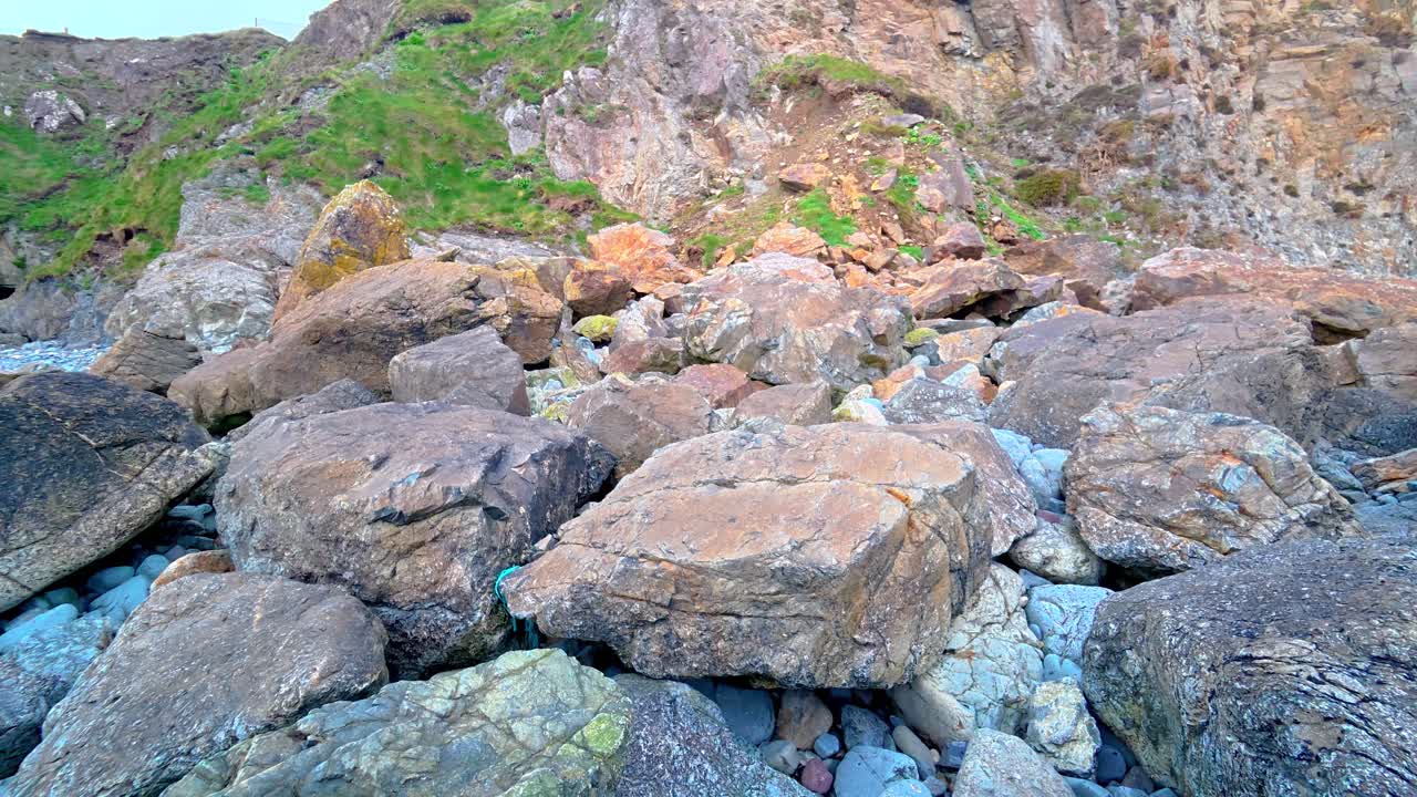 Ripresa ascendente di una caduta massi, di una frana e di una forte erosione costiera dopo le tempeste invernali a Copper Coast, Waterford, Irlanda.
