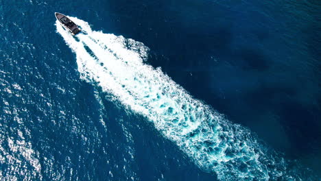 Lancha-Rápida-De-Lujo-Que-Viaja-A-Través-Del-Marco-En-El-Claro-Y-Reluciente-Mar-Mediterráneo-En-Mallorca-Vista-Aérea-De-Arriba-Hacia-Abajo