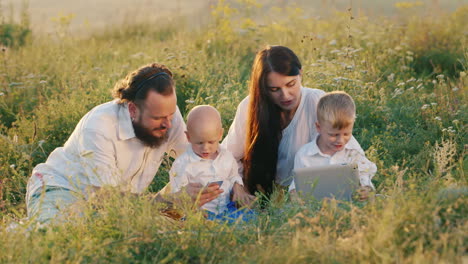 Recreation-And-New-Technologies-Family-With-Children-Playing-With-A-Tablet-And-A-Phone-On-Vacation