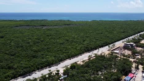 Carretera-Principal-Vacía-En-La-Ciudad-De-Tulum-Que-Conduce-A-La-Zona-Hotelera-Y-Al-Océano-Azul-En-Un-Día-Soleado,-Aérea