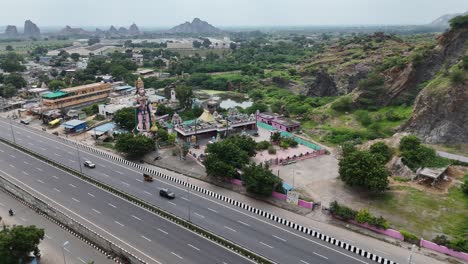 aerial drone shot of hanuman status near a temple on the highway