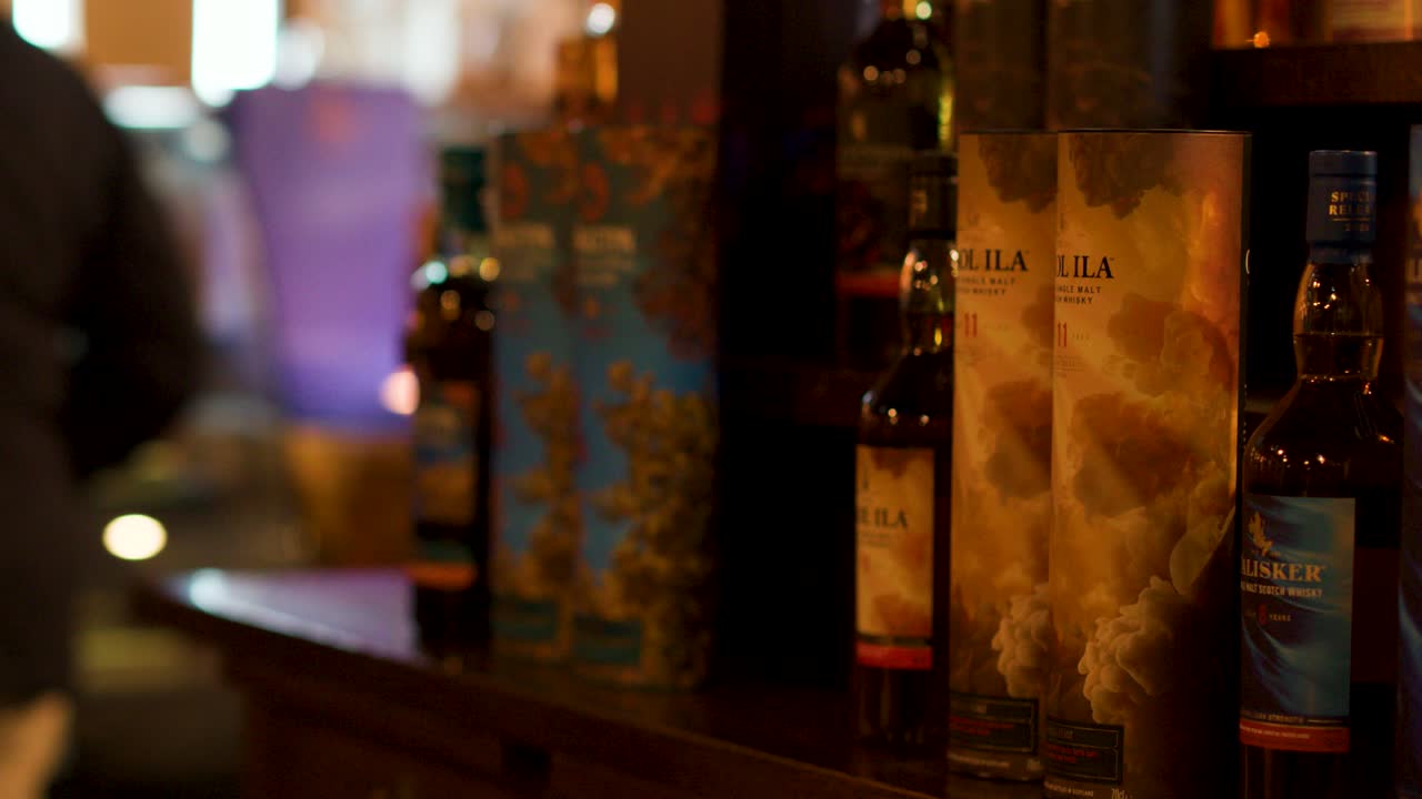Bottles and packaging arranged on wooden counter, warm indoor lighting, slight camera movement, people browsing