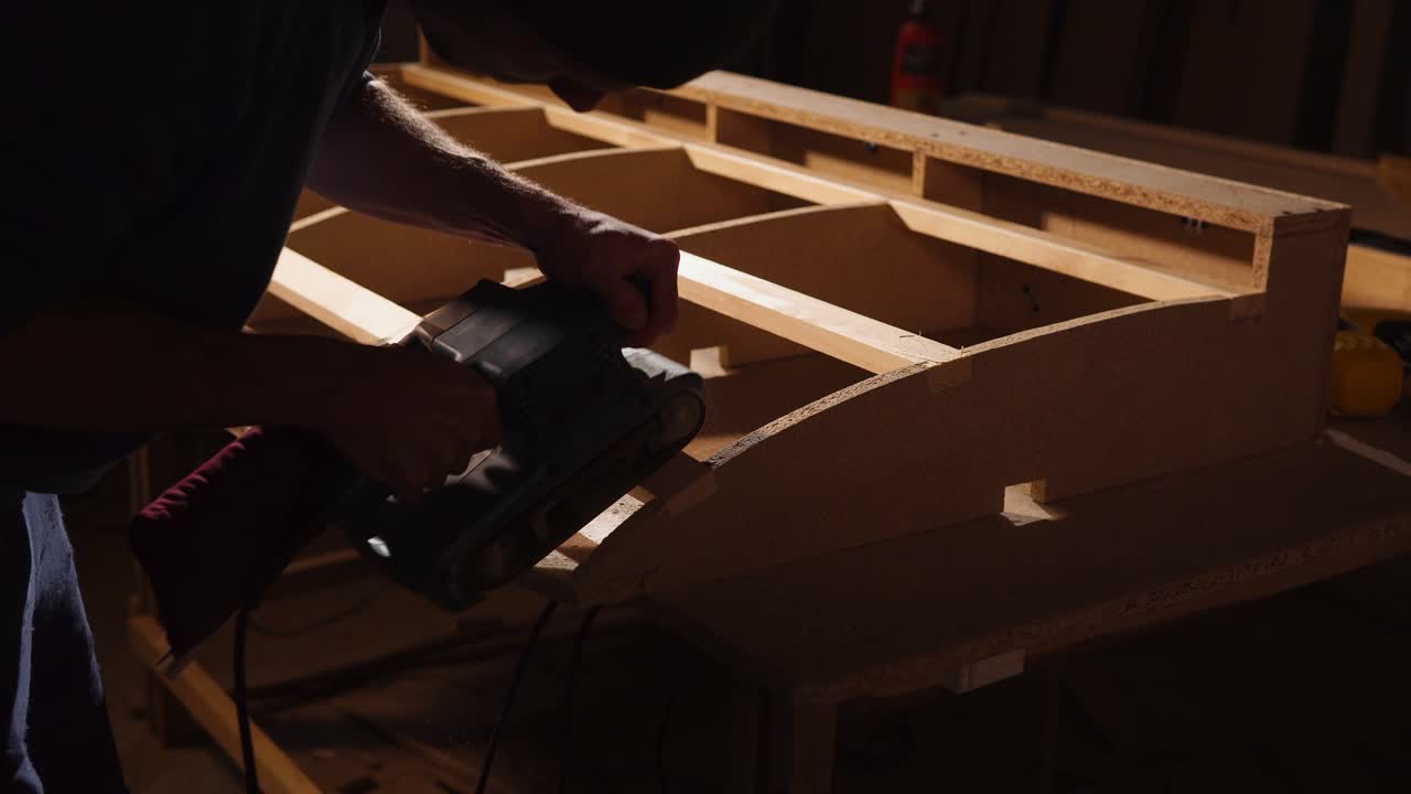 trabajador de la madera lijando un proyecto de madera