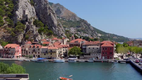 Static-shot-of-a-bridge-over-the-Cetina-River-in-Omis,-Croatia,-with-the-mountains-in-the-background