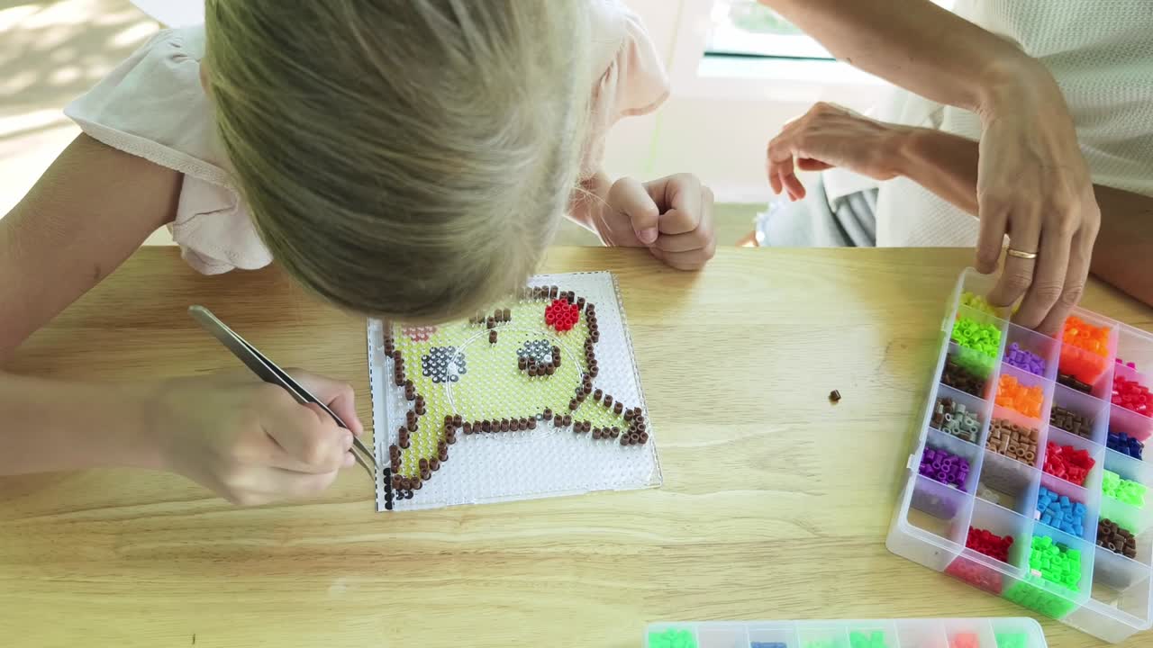 niño y adulto haciendo pixel art de pikachu