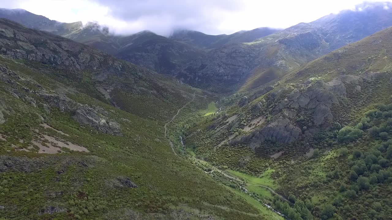 Torrente in una valle con cielo nuvoloso, ripresa aerea.