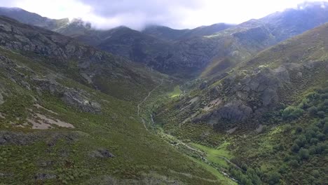 Arroyo-En-Un-Valle-Con-Toma-Aérea-De-Cielo-Nublado