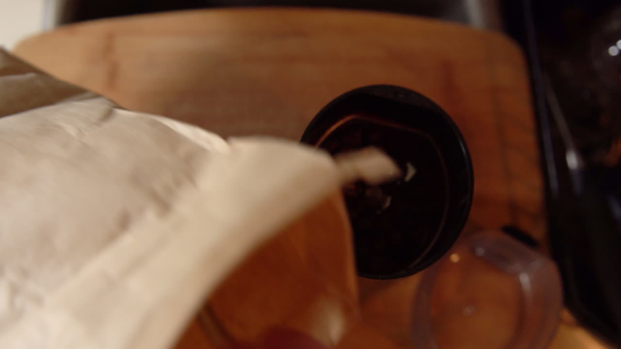 커피 원두를 커피 그라인더에 집어넣는 남자의 하향식 샷