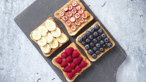 Wholegrain-bread-slices-with-peanut-butter-and-various-fruits