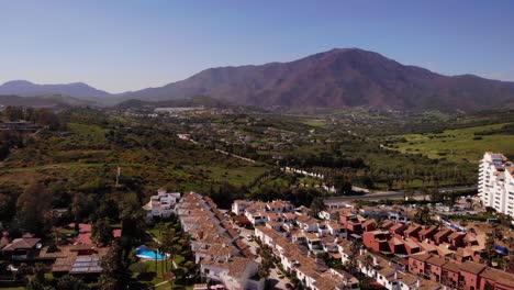 Vista-Aérea-De-Villas-De-Vacaciones-Con-Montaña-De-Fondo-En-Estepona,-Costa-Del-Sol