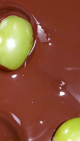 uvas verdes sumergidas en chocolate rico y fluido