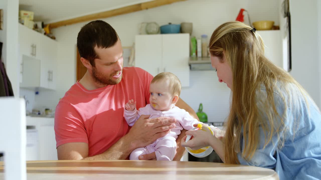 부모가 아기 소년에게 먹이를 주는 4k