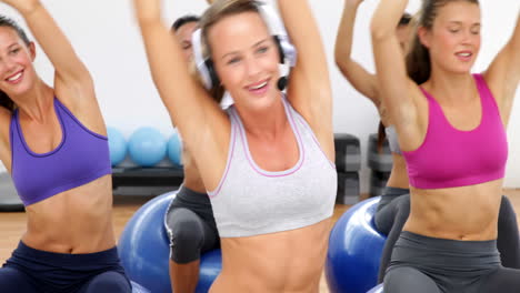 fitness class sitting on exercise balls stretching