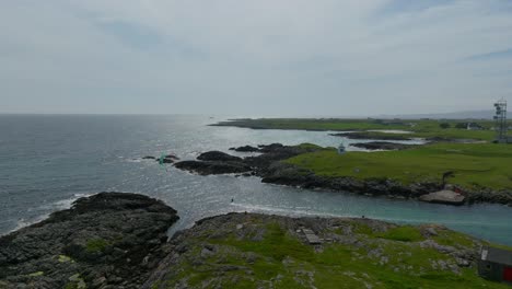 a kitesurfer coming out of a small harbour on the isle of tiree