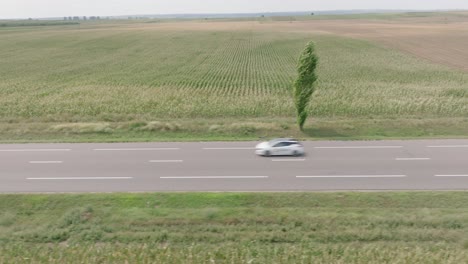 cars driving in the highway passing by on the romanian fields in daytime