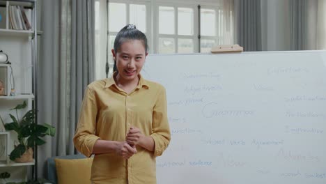 asian female teacher with marker pen teaching english at home